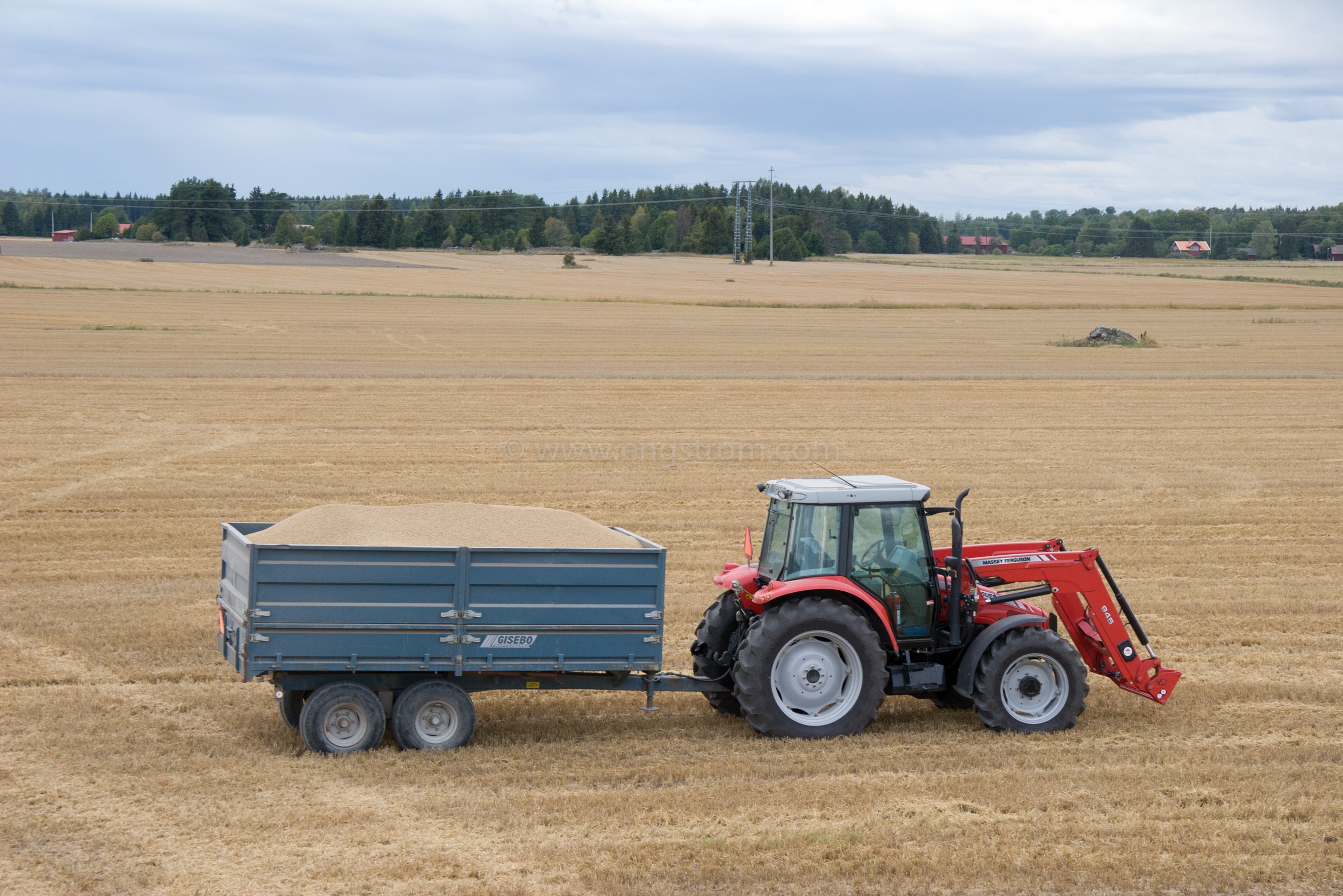 JE_20796, Traktor med spannmålsvagn på tröskad åker, Jonas Engström